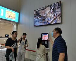 说明: 中心主任鲁平在东二食堂指导新生给餐卡充值